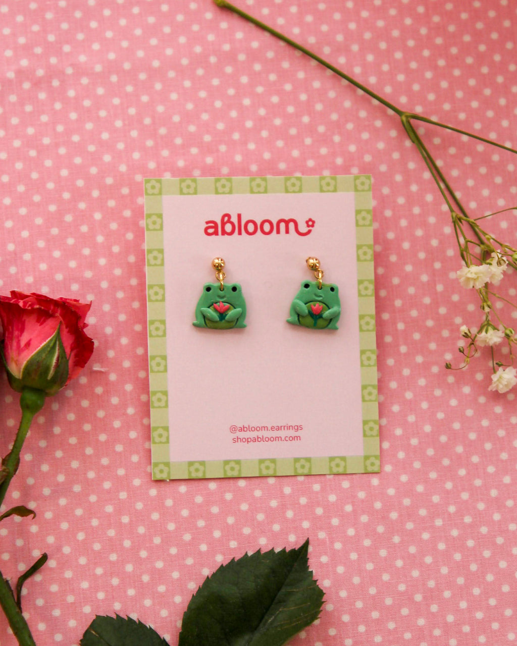 earrings featuring frog/toad's holding a tulip