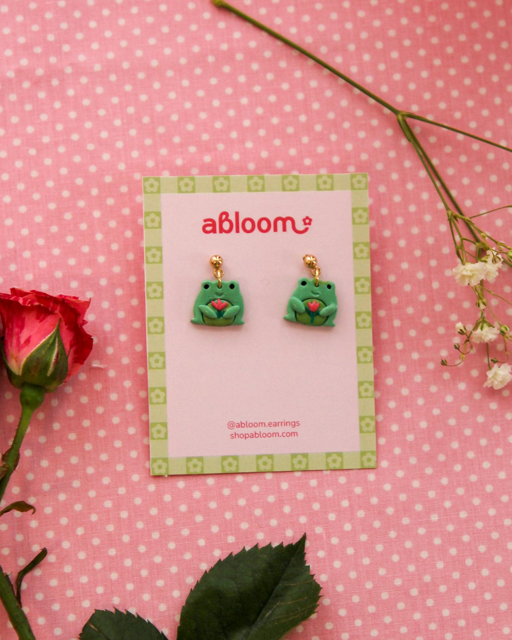 earrings featuring frog/toad's holding a tulip
