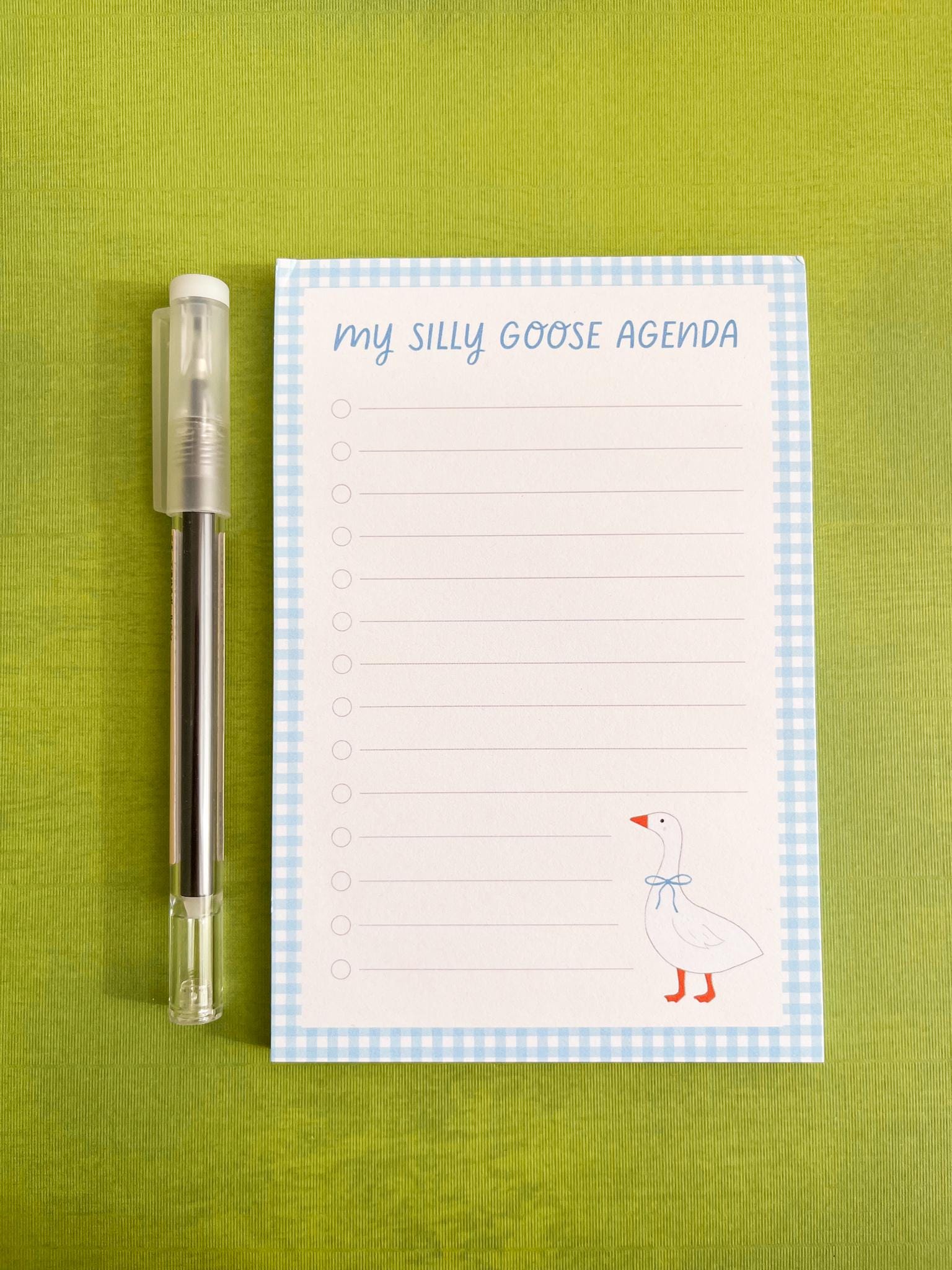 Lined notepad with 'My Silly Goose Agenda' title, lines with checkboxes, a blue gingham trim, and a illustrated goose in the right bottom corner