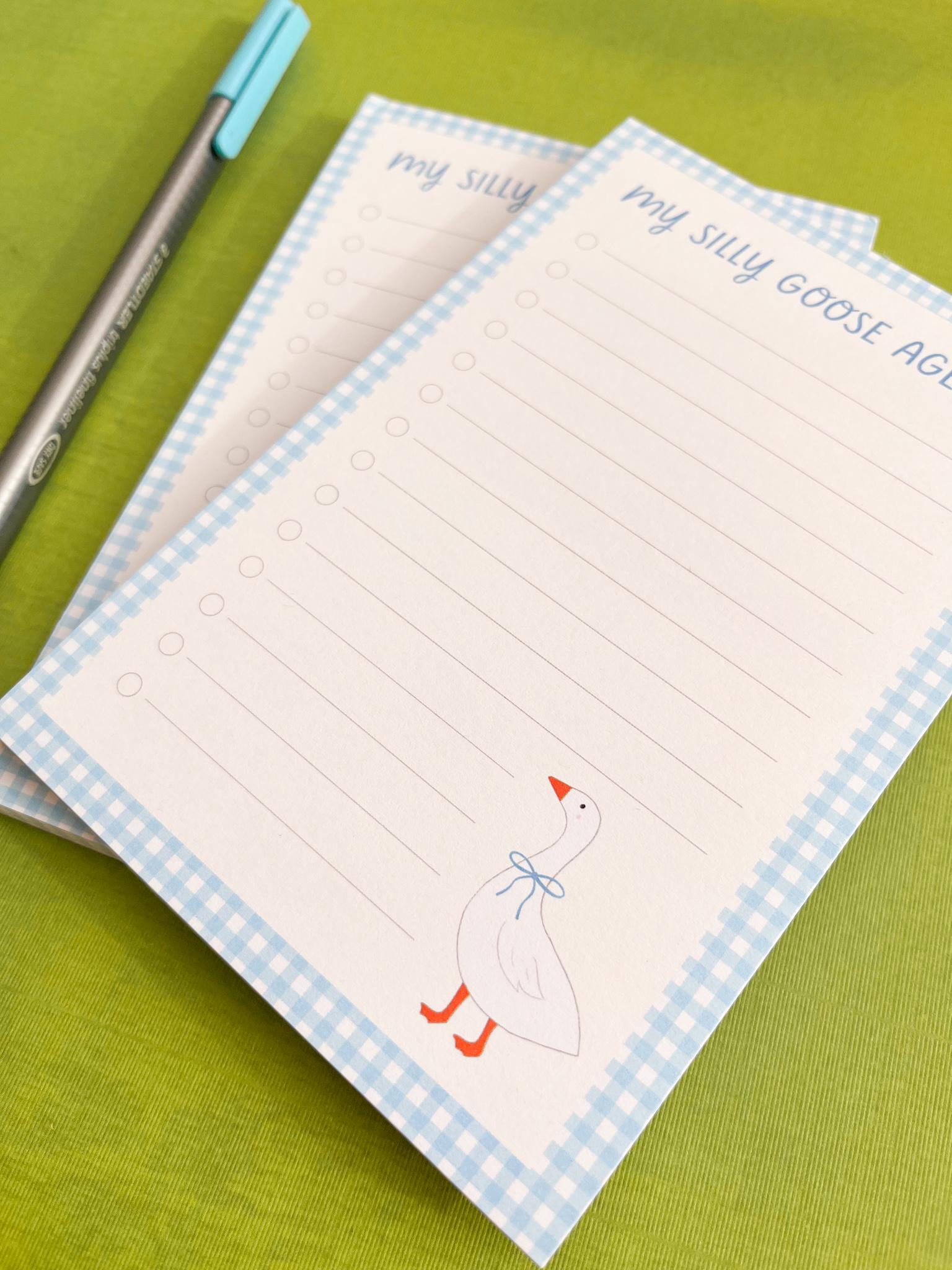 Two notepads with a goose illustration and text on a green background