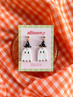 A pair of cute ghost drop earrings with black witch hats.