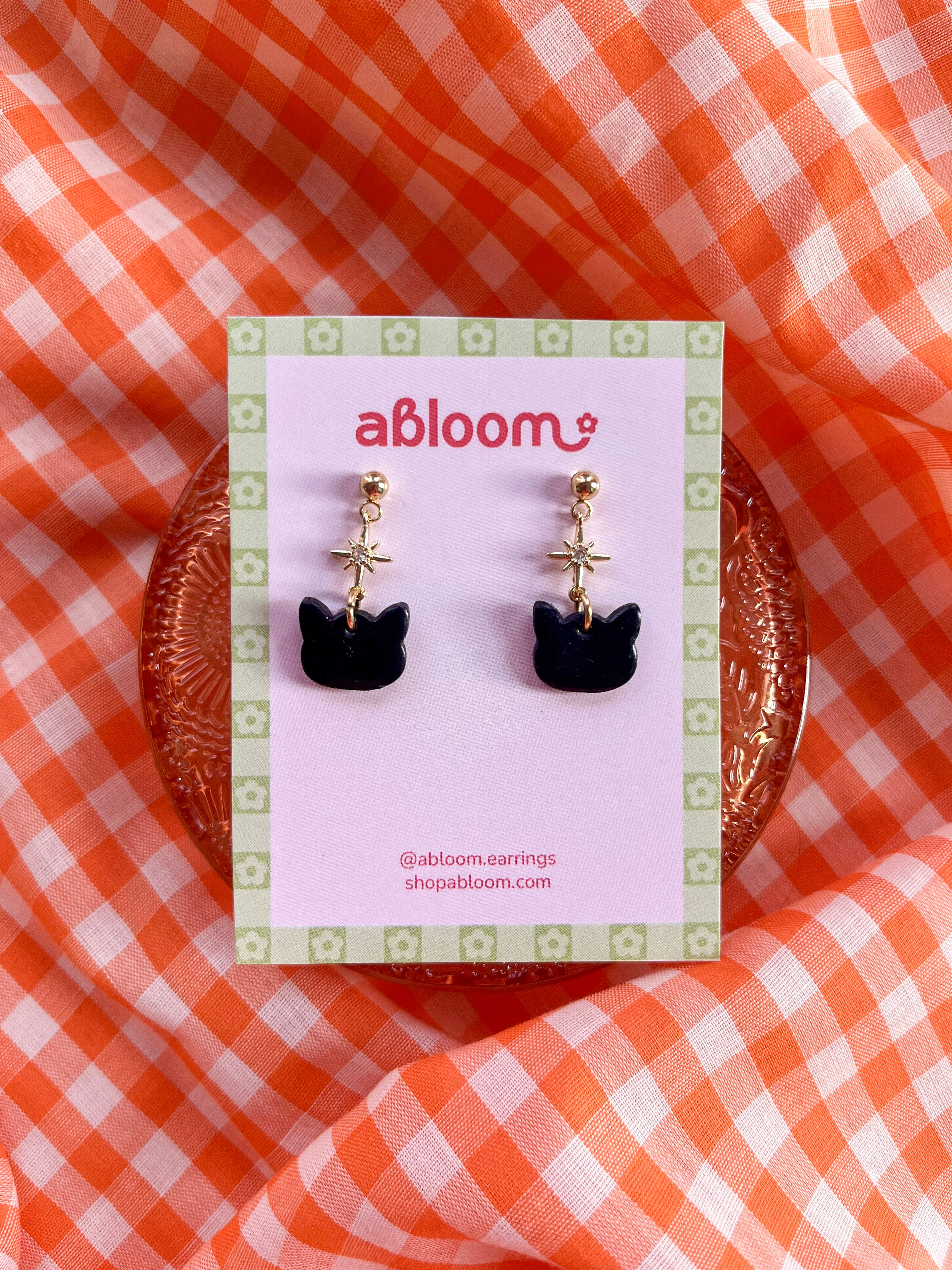 Cute black cat earrings with sparkling star charm handmade from polymer clay