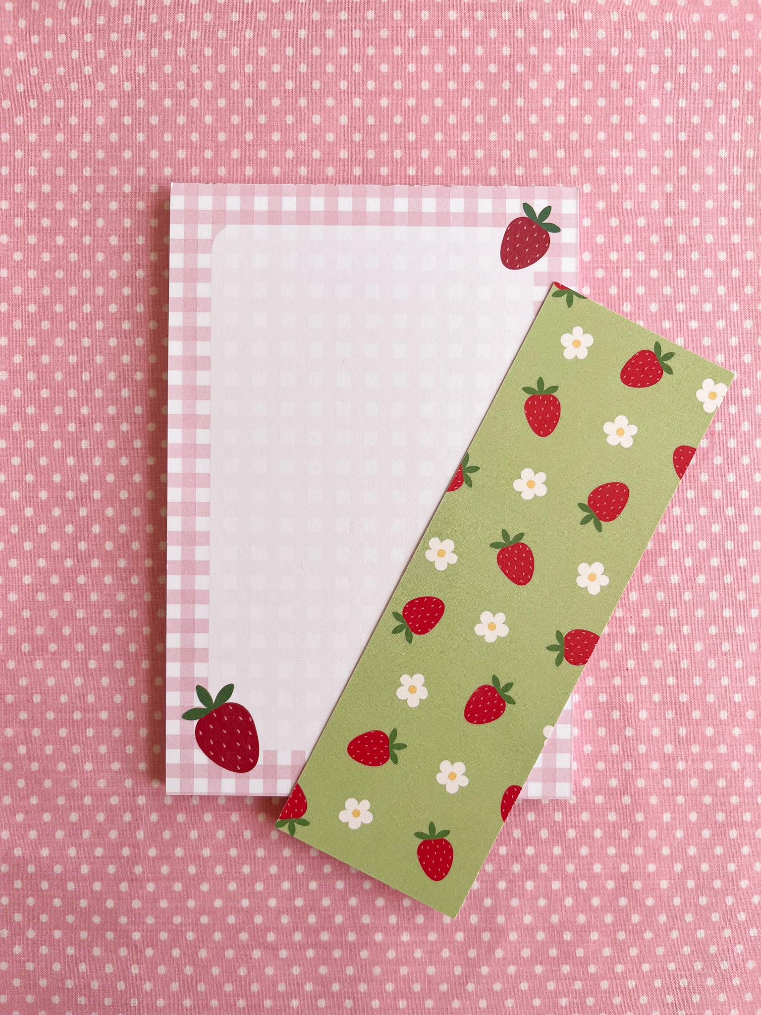 notepad and bookmark with strawberry patterns on a pink polka dot background