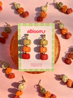 Pumpkin-shaped drop earrings in beige, orange, and red.