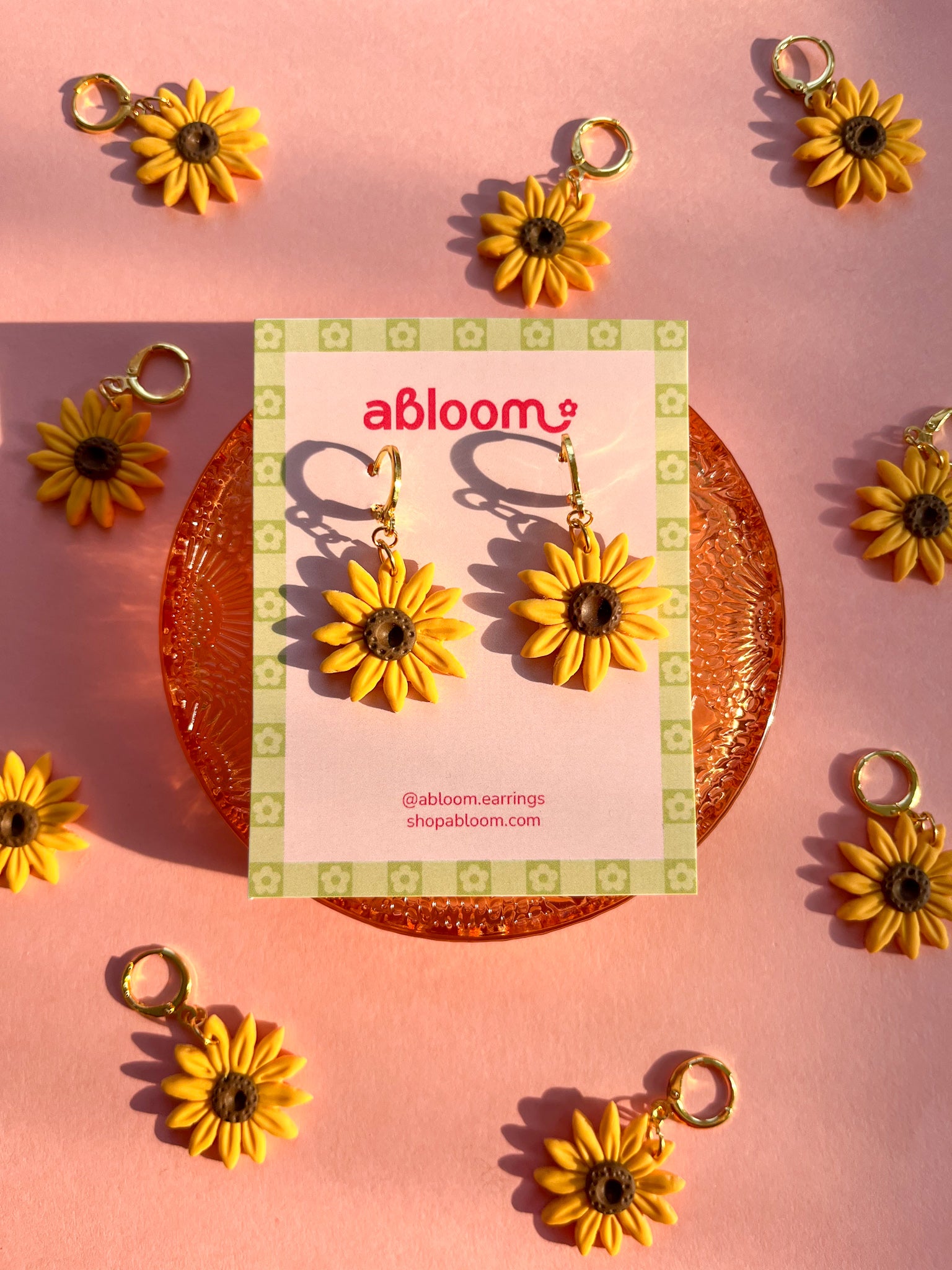 yellow sunflower dangle earrings displayed on an earring card