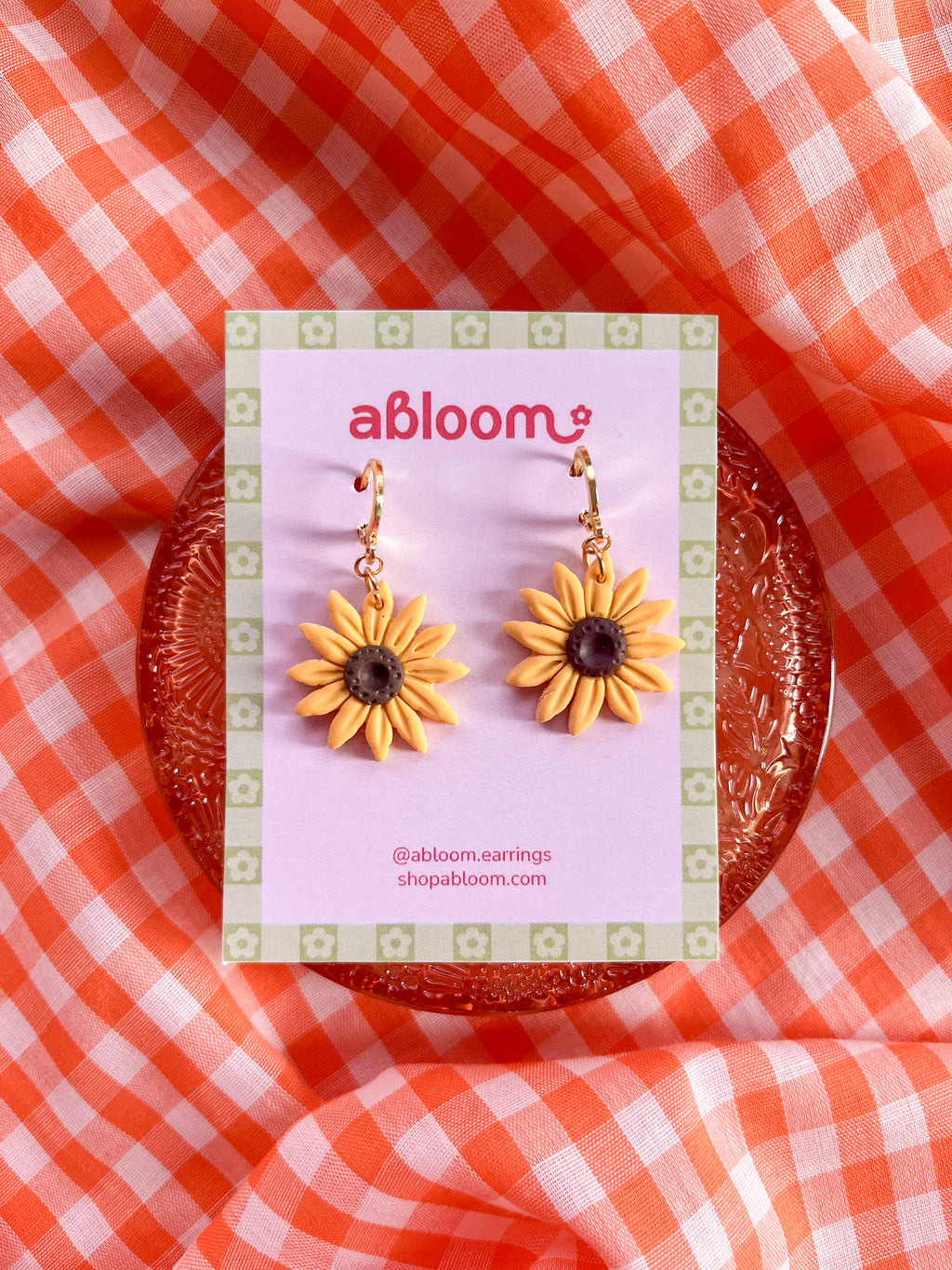 yellow sunflower dangle earrings displayed on an earring card